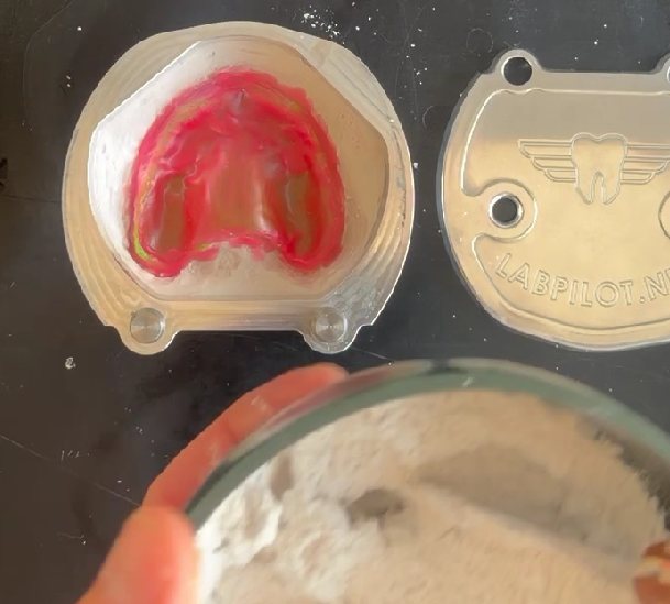 Open flask beside the lid, with mixed plaster ready to pour